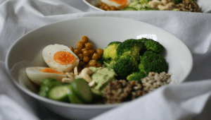 Buddha Bowl mit Kichererbsen, Eiern, Avocado, Brokkoli, Quinoa, Cashew und Gurken