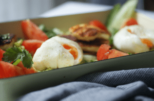 pochierte Eier und gebratener Halloumi auf Avocado Brot mit Gemüse und Koriander